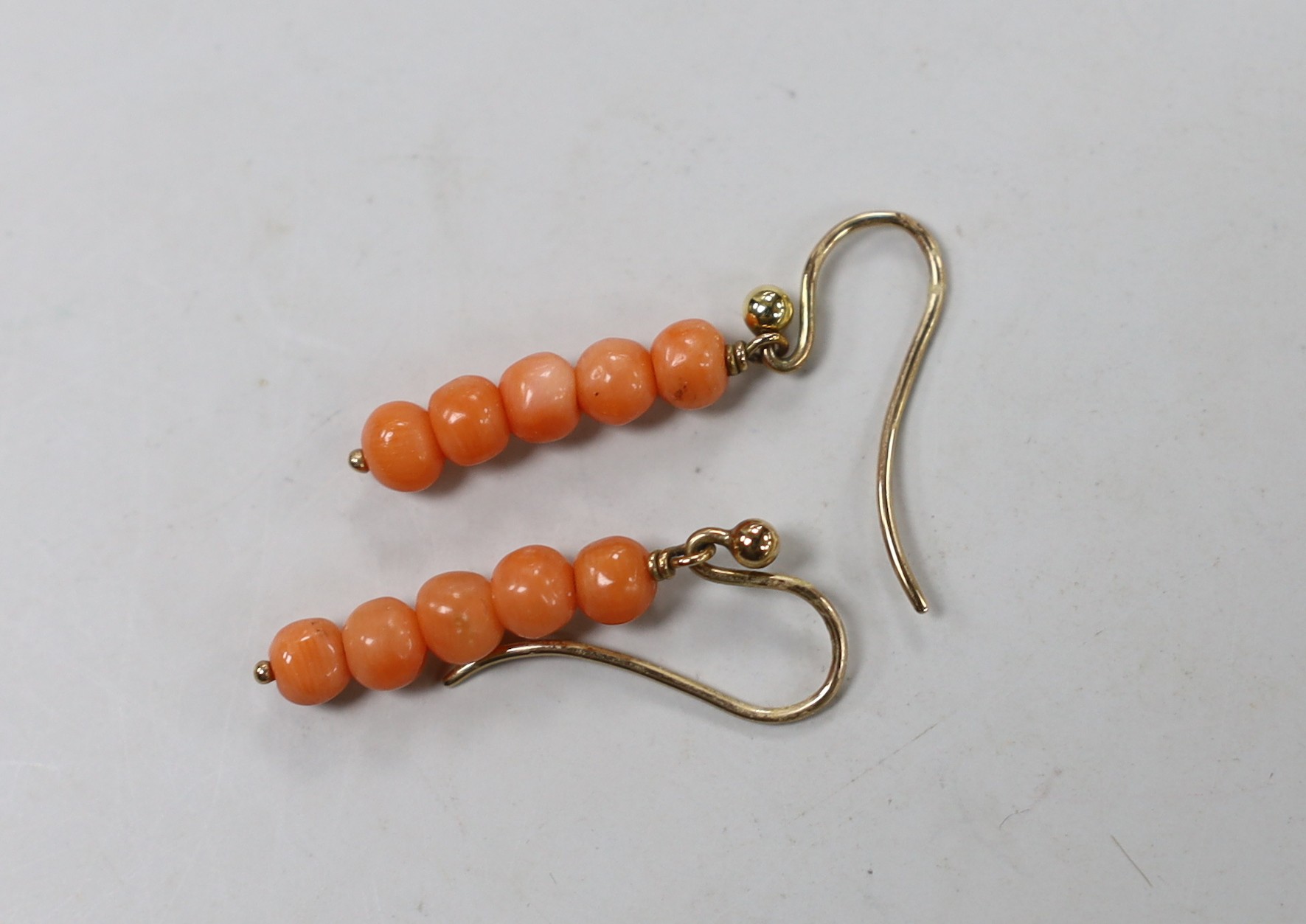 A single strand graduated coral bead necklace, with 9ct clasp, 52cm, together with a pair of coral bead earrings and a small quantity of loose coral beads.